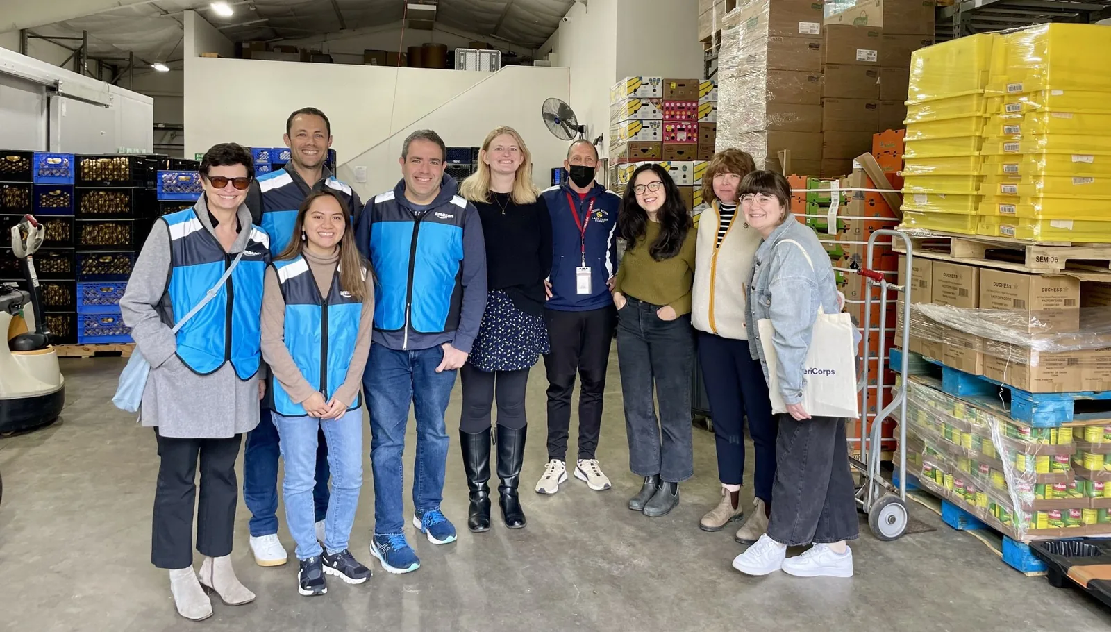 Josh with an Amazon volunteer team inside a food bank warehouse